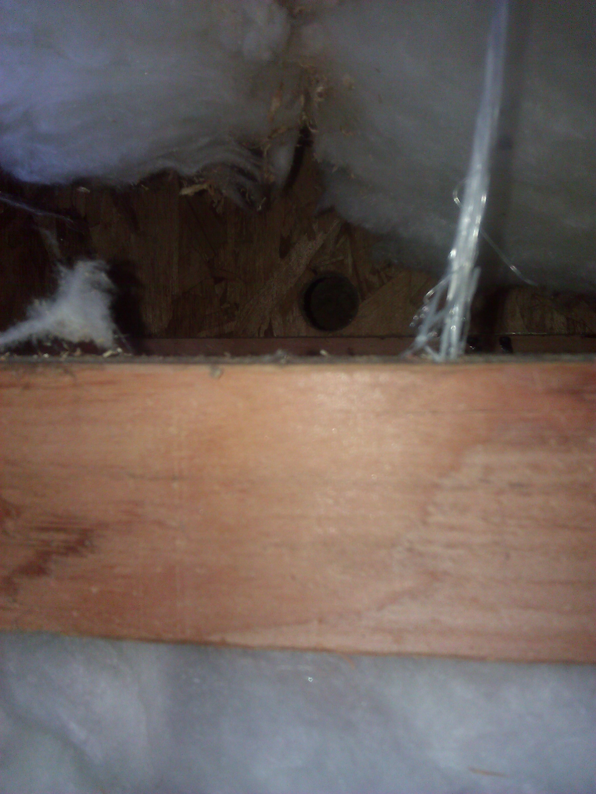 Hole drilled up into the subfloor, behind the fireplace