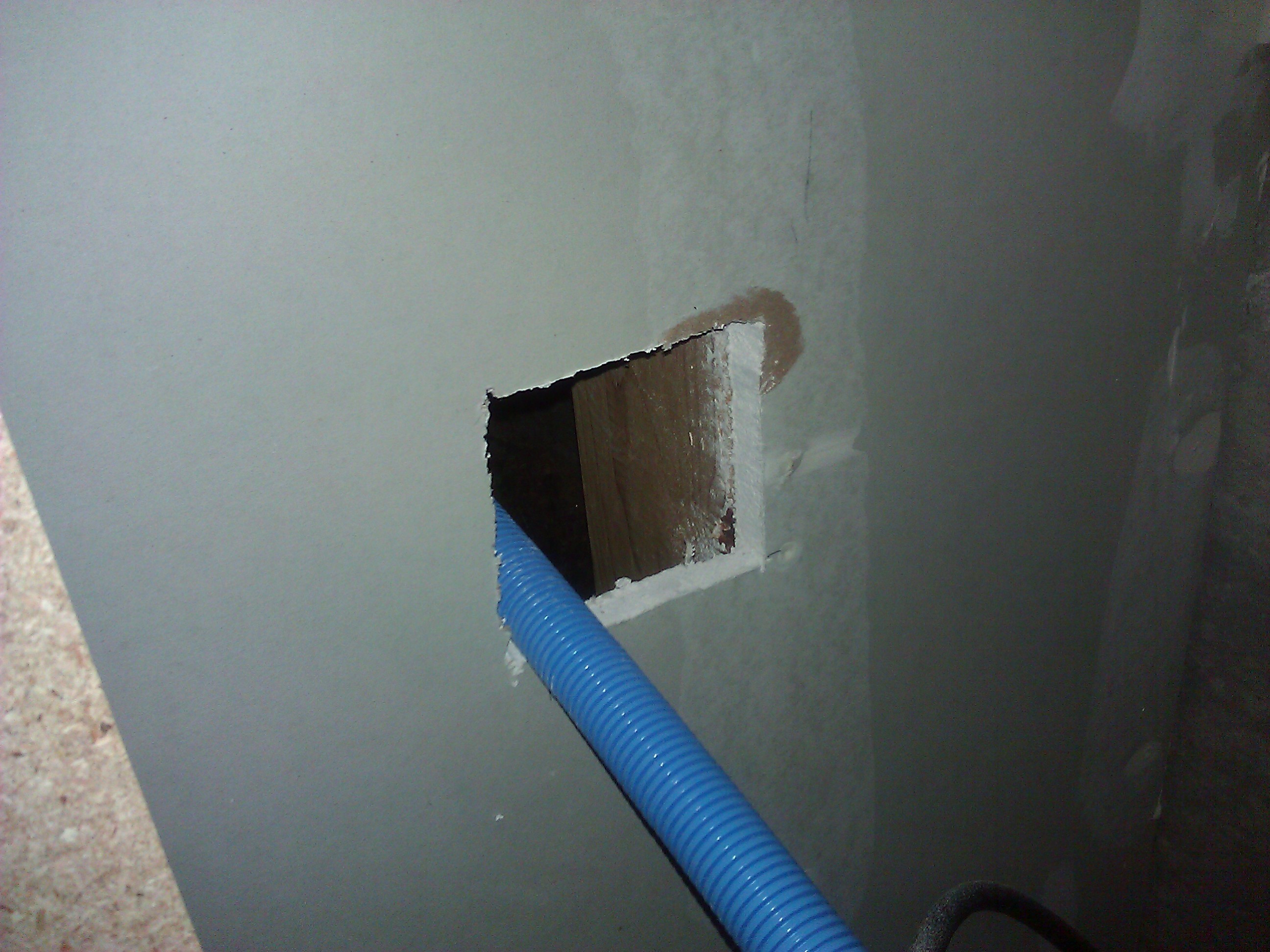 Cut a hole in the garage wall to accept a plastic box